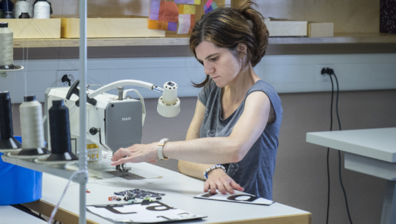eine Klientin arbeitet konzentriert an der Nähmaschine im Atelier von Viv Quimby in St. Gallen-West