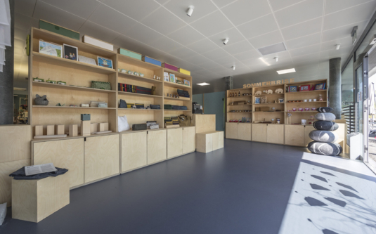 Atelier-Laden von Viv Quimby mit hellen Holzregalen, in denen sich Produkte aus Holz und Textilien befinden