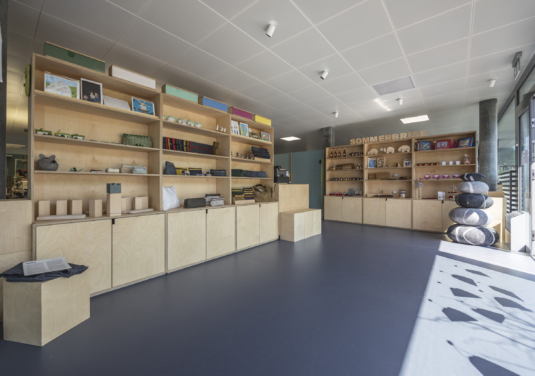 Atelier-Laden von Viv Quimby mit hellen Holzregalen, in denen sich Produkte aus Holz und Textilien befinden